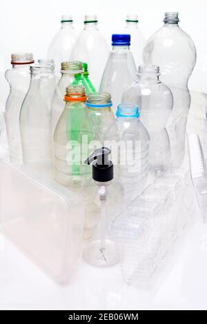 A collection of household plastic based material shot on a white background with reflection. Bottles, food trays, pump container ready for recycling. Stock Photo