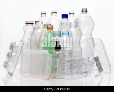 A collection of household plastic based material shot on a white background with reflection. Bottles, food trays, pump container ready for recycling. Stock Photo