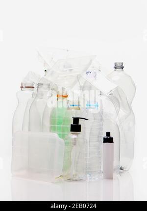 A collection of household plastic based material shot on a white background with reflection. Bottles, food trays, pump container ready for recycling. Stock Photo