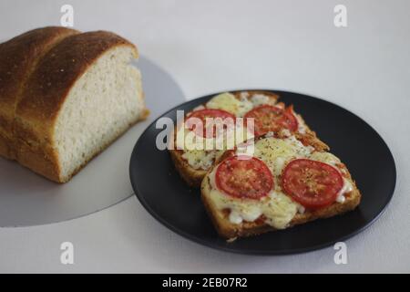 Pizza toast with home baked bread loaf. Shot on white background. Stock Photo