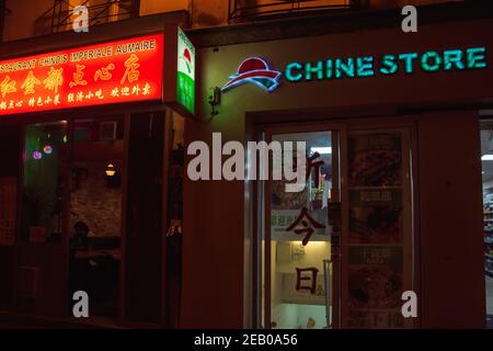 Urban evening scene in oldest Asian quarter of Paris (3 district). People shop in local stores; eat in popular Chinese, Vietnamien, Korean restaurants Stock Photo