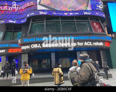 Visitors to Times Square in New York watch the WABC news ticker during the inauguration of 46th President Joseph Biden and Vice-President Kamala Harris on Wednesday, January 20, 2021. (© Frances M. Roberts) Stock Photo