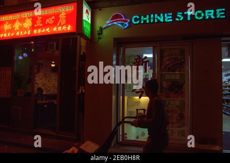 PARIS, FRANCE - OCTOBER 19, 2019:  Urban evening scene in old Asian quarter of Paris (3 district). People shop in local store; eat in popular Chinese, Stock Photo