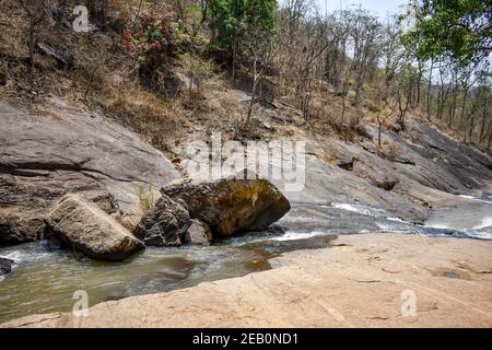 awesome view of waterfall passing through a mountain big rock near by water reservoir. Stock Photo