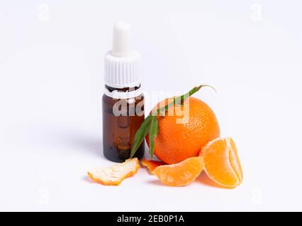 isolate, glass vial with pipette and tangerine on white background Stock Photo