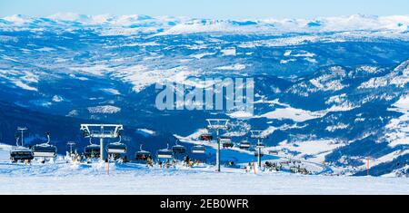 Panoramic view over a ski resort with people in chair lifts. Stock Photo