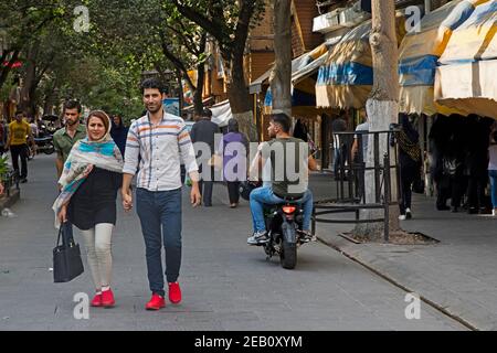 Streetscene showing young Iranian couple walking in shopping street in the city Tabriz, East Azerbaijan Province, Iran Stock Photo