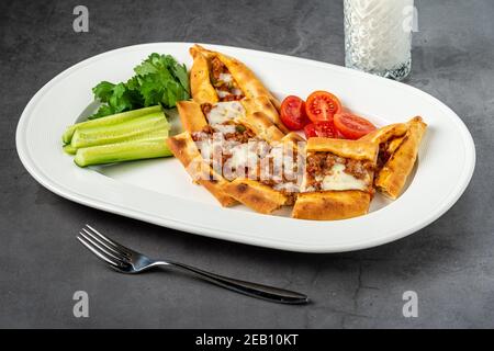Sliced ​​minced meat pita with buttermilk and salad on stone table. Stock Photo