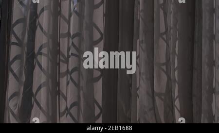Dark net or voile curtains at window with leaded light design showing through Stock Photo