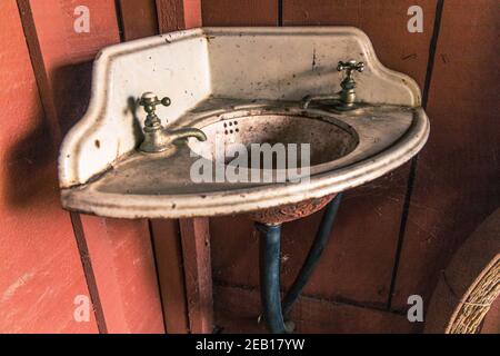 Old dirty corner sink and faucets (taps) at Rancho Los Alamitos Historic Ranch and Gardens Bixby Hill Long Beach, California USA Stock Photo