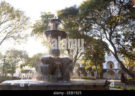 Central park of Antigua Guatemala at sunrise - Fountain of the Sirens in the middle of the park in Colonial Guatemala City Stock Photo