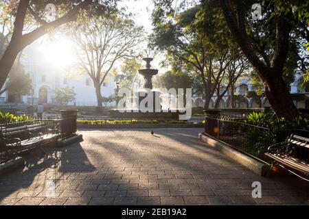 Central park of Antigua Guatemala at sunrise - Fountain of the Sirens in the middle of the park in colonial Guatemala City - Empty park early in the m Stock Photo