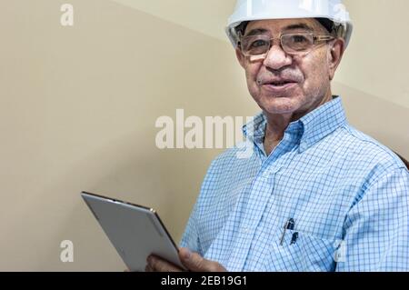 Man in white helmet with a tablet in his hands Stock Photo