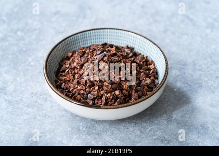 Chocolate Cacao Nibs or Cocoa Nibs in Bowl Ready to Use on Dark Wooden Surface. Ready to Eat. Stock Photo