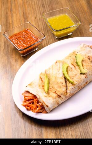 Mexican burrito with copy space. Mexican food on wooden table. Stock Photo