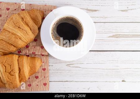 fresh croissants and coffee on light wooden background with copy space. Stock Photo