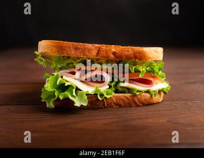 Sandwich with bacon and vegetables on a dark background. Macro Stock Photo