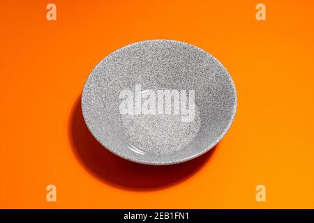 one gray plate on an orange background Stock Photo