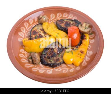 Delicious grilled vegetables on a clay plate. Isolated on a white background. Stock Photo