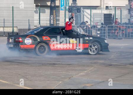 Kazan, Russia-September 26, 2020: The driver of the sedan burns tires during a drift in the parking lot, the passenger climbed out of the open window Stock Photo