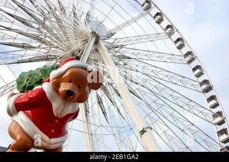 PARIS, FRANCE - JANUARY 14, 2018: Bear in Santa costume inviting to Christmas market at Place de la Concorde near Tuileries Garden and ferris wheel at Stock Photo