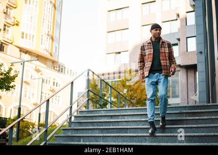 Confident stylish young afro american man walking on a street Stock Photo