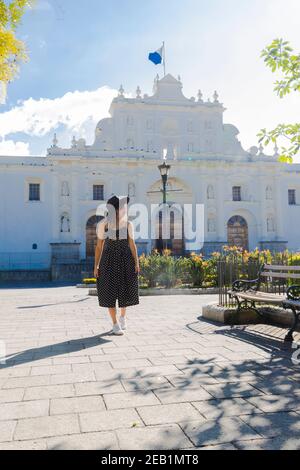 Young Hispanic woman standing in front of the San Jose cathedral in Antigua Guatemala - travel tourist in colonial city - central park of Antigua Guat Stock Photo