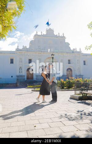 Hispanic couple seeing each other in front of the San Jose cathedral in Antigua Guatemala - young tourists enjoying their vacations in the colonial ci Stock Photo