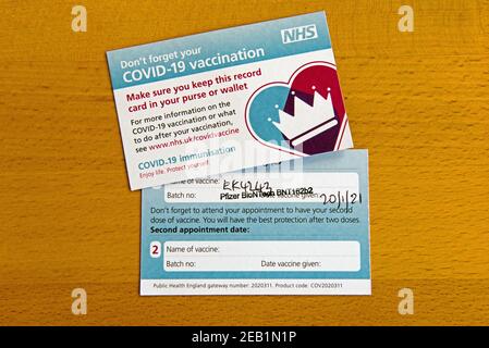 Two Covid-19 Vaccination card or vaccine cards to show type of vaccine Pfizer on reverse Stock Photo