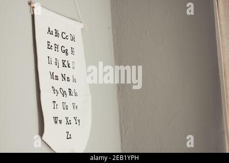 Lowercase and uppercase pairs of English alphabet letters on a white material suspended from a wall Stock Photo