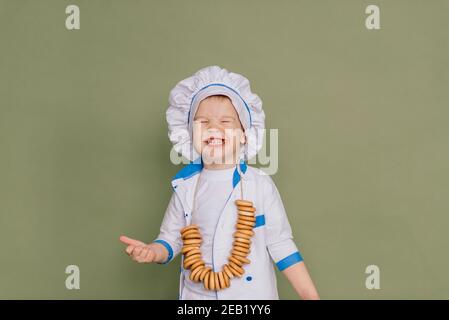 Portrait of a little boy cook holding pan at the kitchen. Different occupations. Isolated over white background. Twin brothers Stock Photo