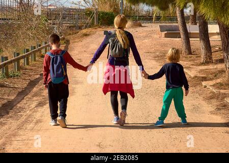 Blonde girl holding hands with two children. sport clothes, caucasian, blond, blonde, blonde, siblings, mother sport happy lifestyle Stock Photo