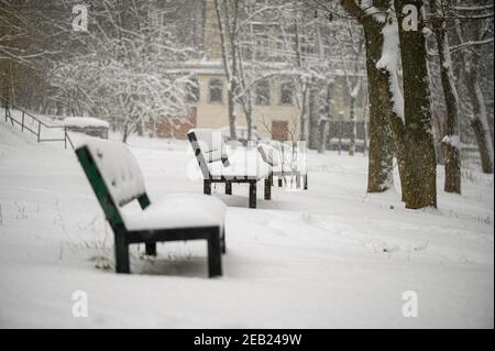 Snow covered benches in residential area park Stock Photo