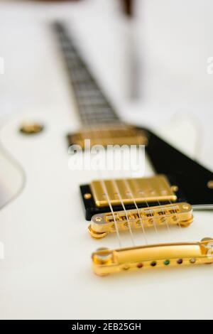 White Gibson guitar on background of white bed sheets. Stock Photo