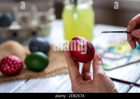 Woman painting Easter egg. Homemade decoration for traditional religious celebration. Art and craft concept with femal hands Stock Photo