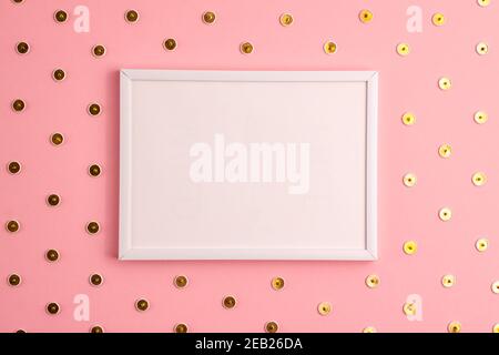 Mockup of white frame and gold colored push pins pattern around it on pink background. Flat lay top view. Education template back to school and online Stock Photo