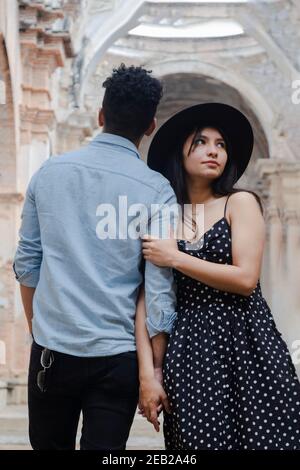 Young woman hugging her boyfriend while visiting famous ruins in Antigua Guatemala on their romantic vacations -couple in love on trip Stock Photo