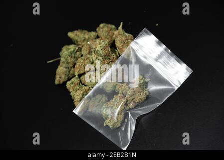 Cannabis buds in a small plastic bag s on a table Stock Photo