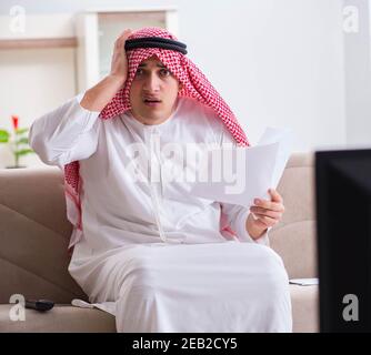 The arab businessman watching tv at home Stock Photo