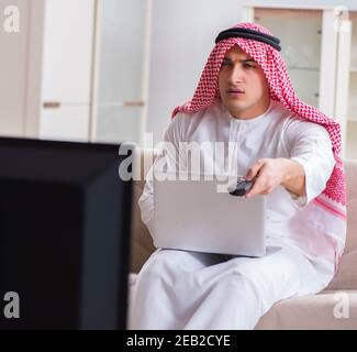 The arab businessman watching tv at home Stock Photo
