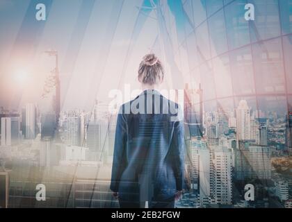 Business Property Development and Investment Concept, Double Exposure of Businesswoman Rear View and Cityscape Buildings. Goal Business Executive Mark Stock Photo