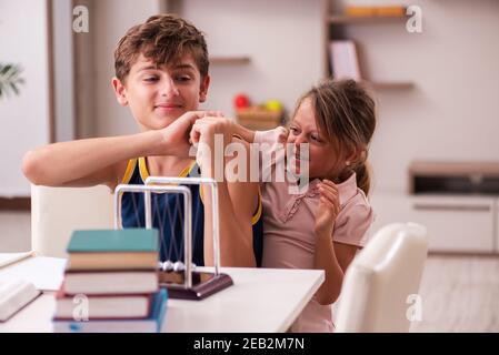 Teenager and his small sister staying at home during pandemic Stock Photo