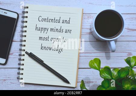 Text on notepad with cup of coffee, smart phone and pen on wooden table Stock Photo