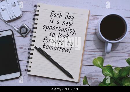 Text on notepad with cup of coffee, smart phone and pen on wooden table Stock Photo