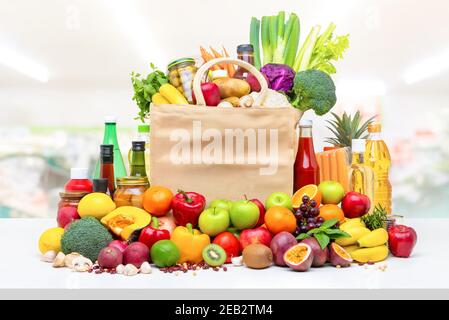 Colorful food and groceries including fresh fruits and vegetables on white countertop in supermarket background Stock Photo