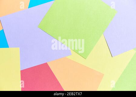 Colorful background: square sheets of paper of different colors filling the frame. Office or school supplies, for taking notes or for making origami o Stock Photo