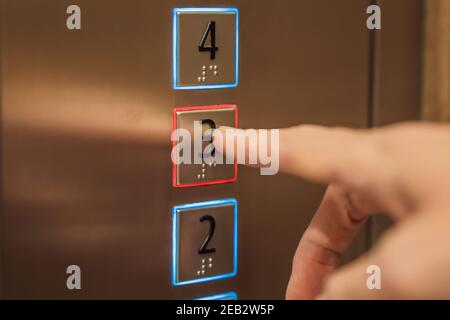 finger presses the number on the elevator button Stock Photo