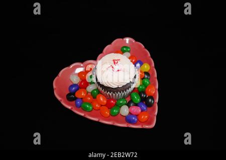 Cupcake on Heart-Shaped Plate with Jelly Beans Stock Photo