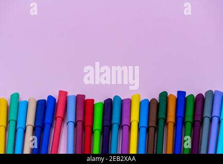 colorful of color pen isolated on pink background. bright colored markers with caps lie on a pink table Stock Photo