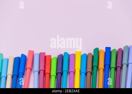 colorful of color pen isolated on pink background. bright colored markers with caps lie on a pink table Stock Photo